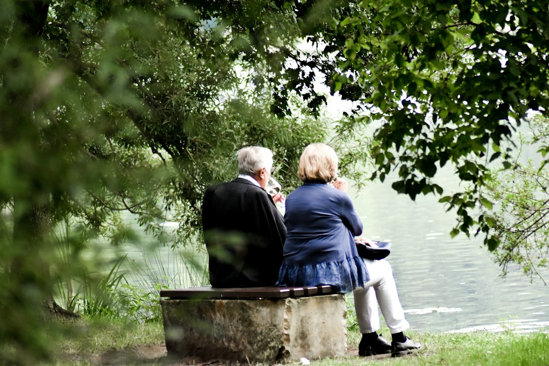 Couple de retraités assis ensemble au bord de l eau