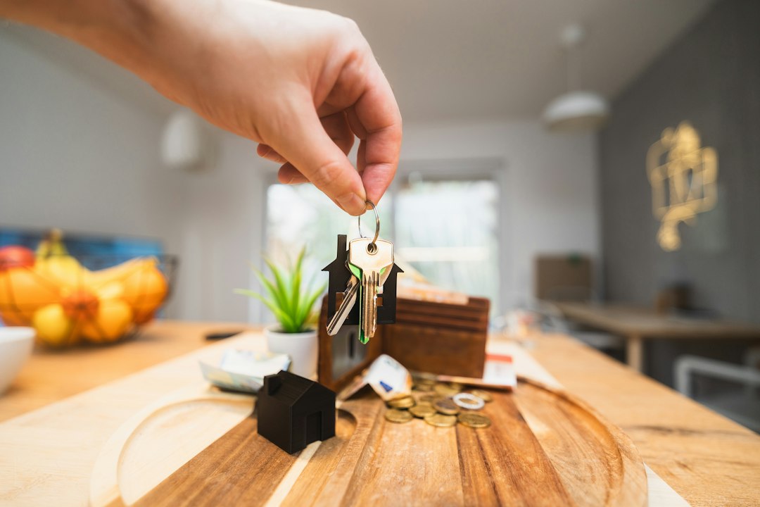 Main tenant des clés de maison et un portefeuille