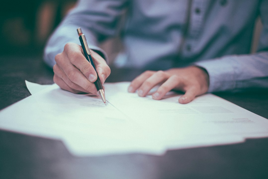 Signature d un document avec un stylo sur un bureau