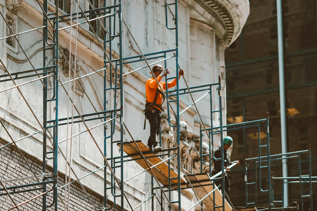 Ouvriers sur une échelle devant la façade d un immeuble
